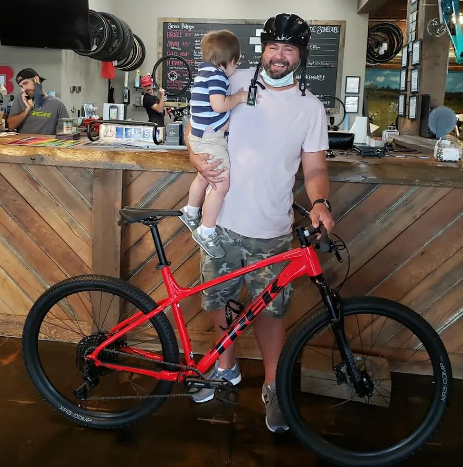 Lucas Shaffer picking up his first mountain bike at Trek of Columbus in 2020, holding his youngest son Rhett